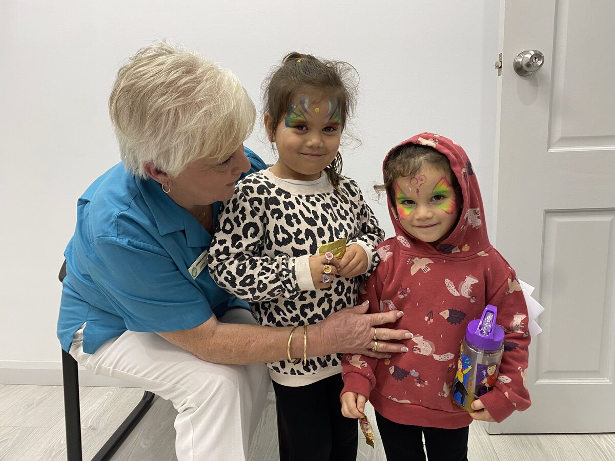 Staff member with children at community event