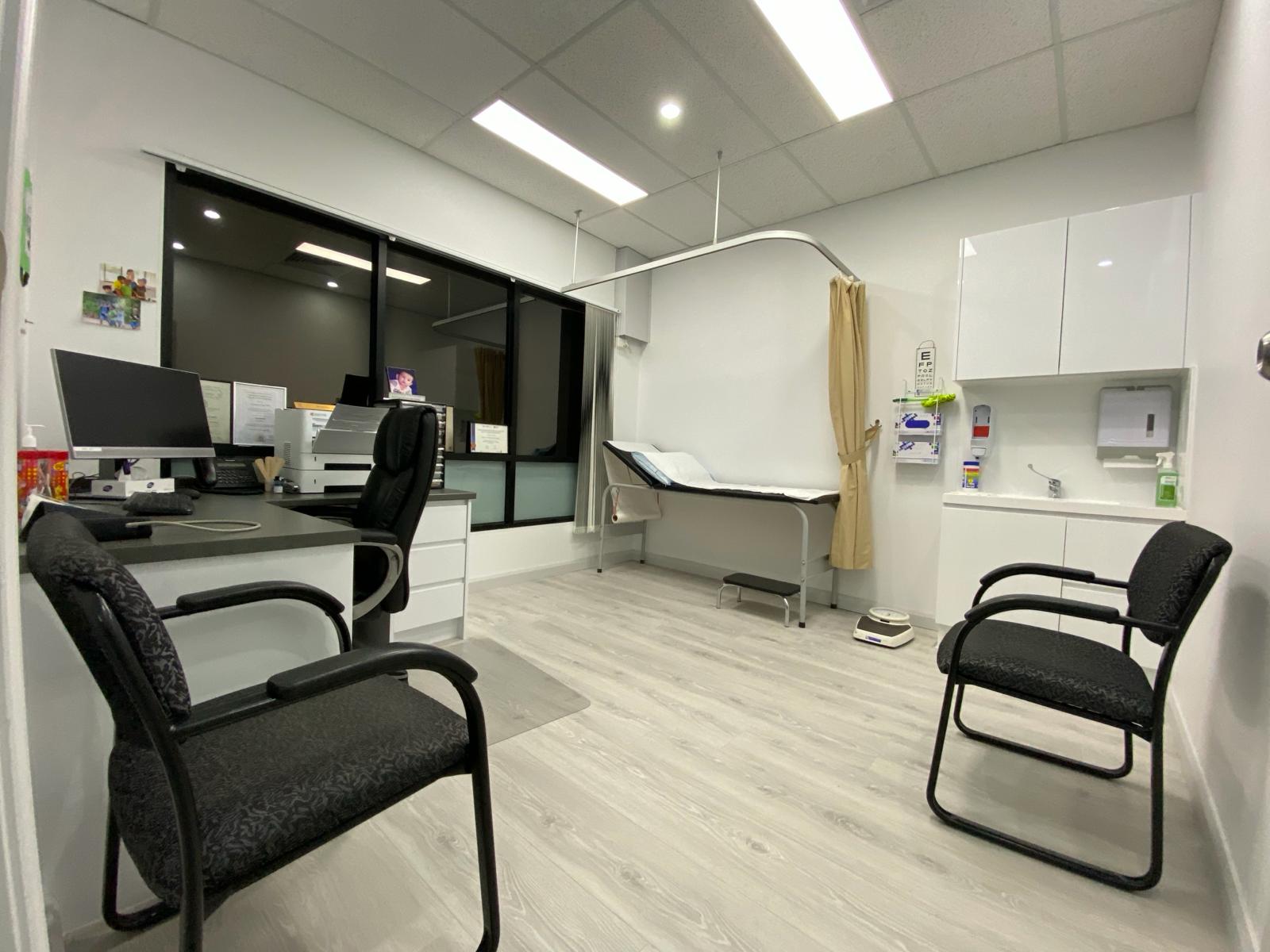 Consultation room with eye chart and examination bed